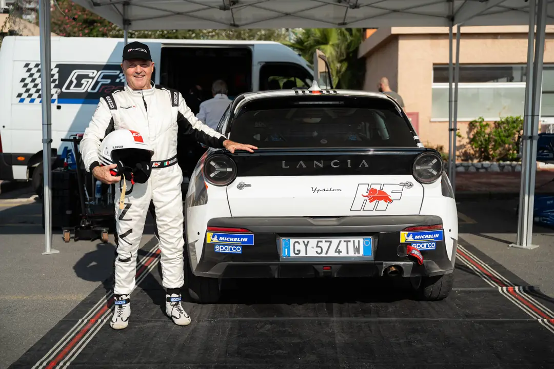 Nell'immagine si vede Miki Biasion che posa a fianco della Lancia Ypsilon HF rally