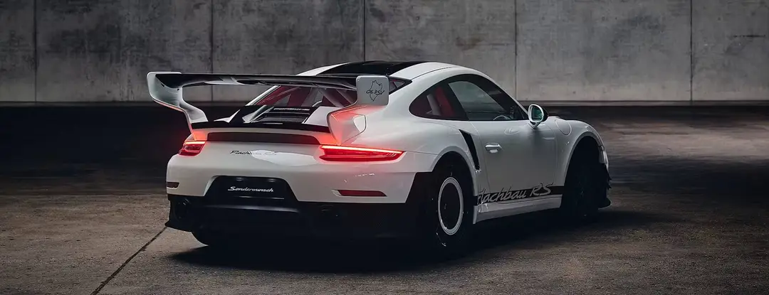 Porsche_911_Flachbau_RS__rear_view_in_dark_studio_hero_desktop_