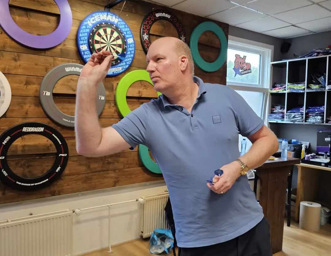 Vincent van der Voort gooit een pijltje in zijn eigen dartshop