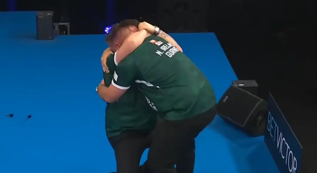 Josh Rock en Daryl Gurney vielen elkaar in de armen na de winnende dubbel