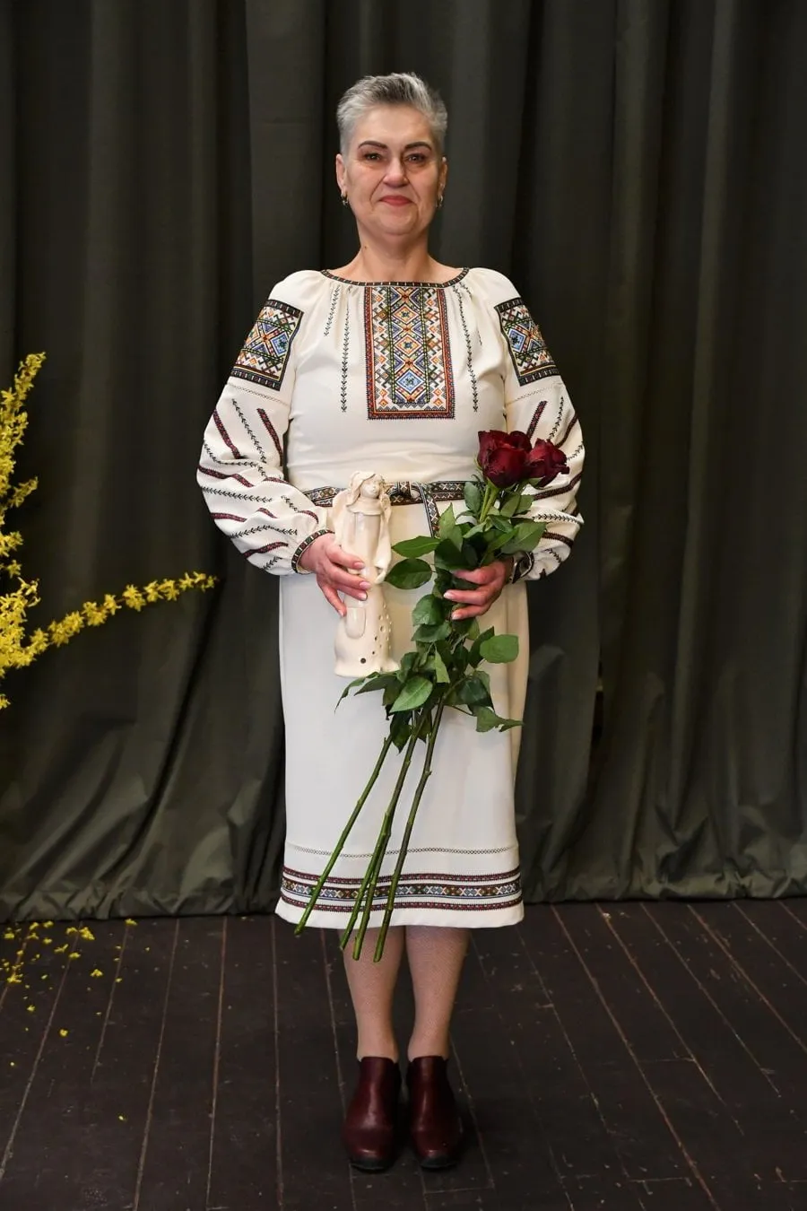 alytaus rajono neigaliuju draugijos pirmininke liudmila makseliene sveikino susirinkusias motinas pasipuosusi tautiniais ukrainieciu kostiumo motyvais