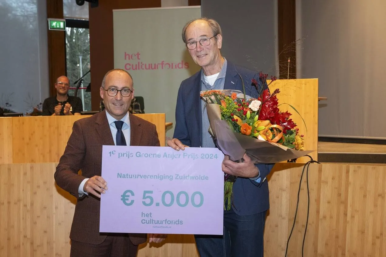Joop Verburg, oud-voorzitter van de Natuurvereniging Zuidwolde, neemt de cheque in ontvangst van Anno Wietze Hiemstra.