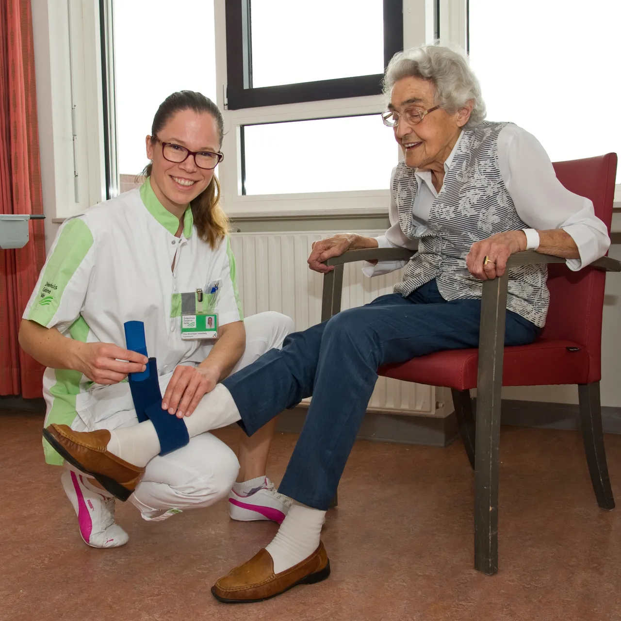 fysiotherapeut flora strookappe bevestigt de activiteitenmeter bij mevrouw kranenburg hensen