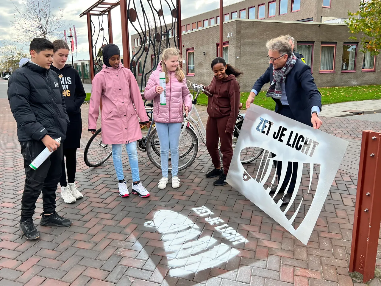 zet je licht aan wethouder van putten spuit met kinderen markeerspray op shared space middelharnis 2