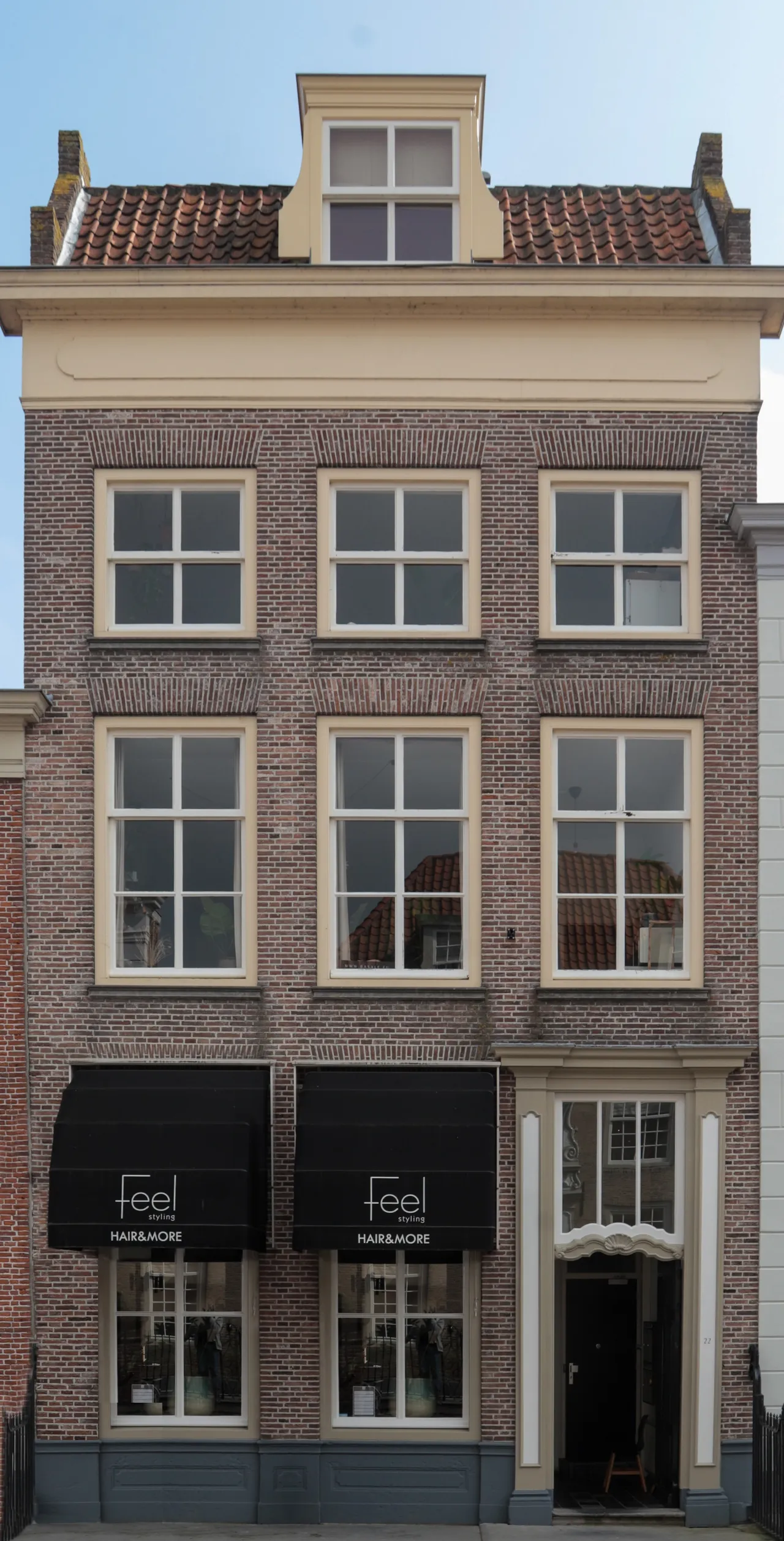 Vooraanzicht van het pand, waarbij de winkelruimte nu een kapsalon en nagelstudio is
