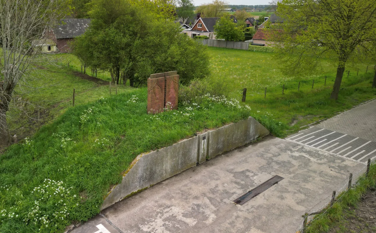 Overzichtsfoto van de Hoge Maasdijk, de Bokhovenseweg, de coupure met schotbalkopeningen en het kunstwerk.