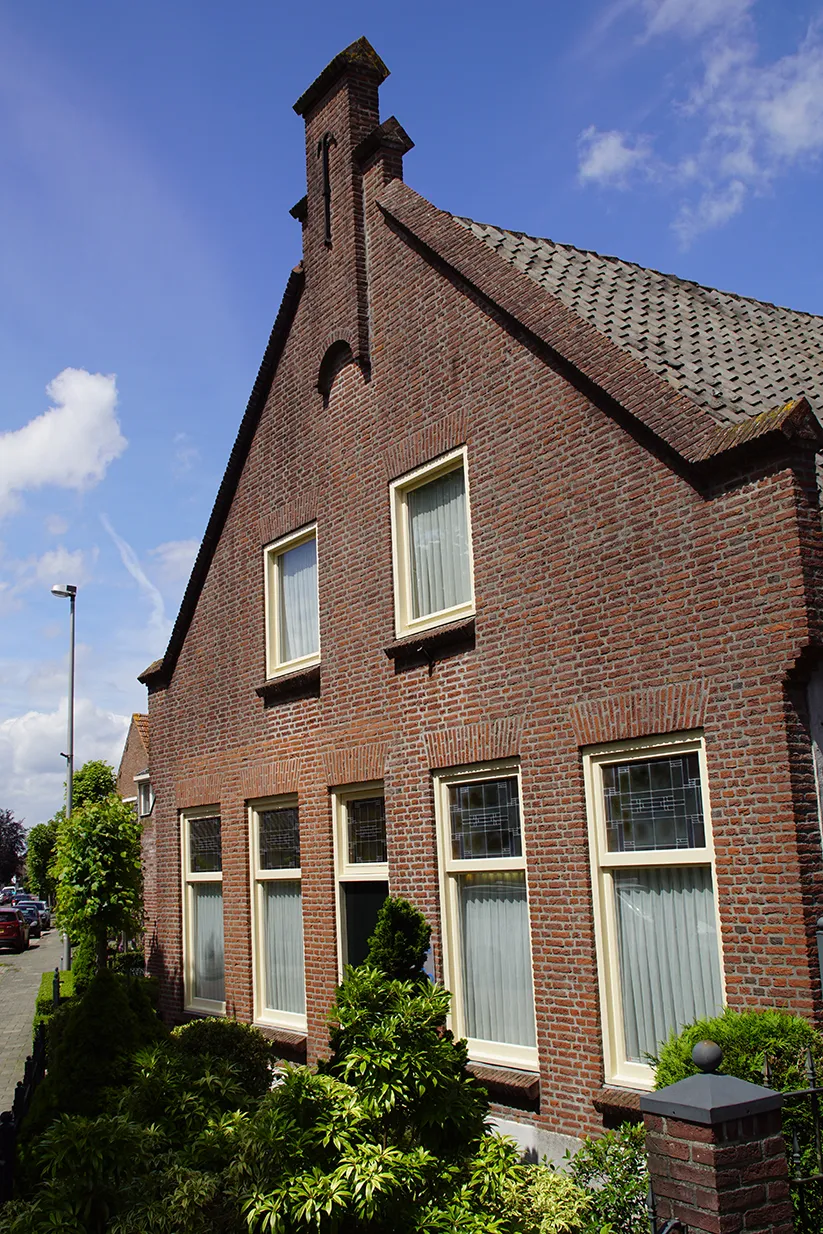 De tuitgevel heeft op de top een versierend tuitstuk. De bovenzijden van de geveldelen zijn afgewerkt met gemetselde ezelsruggen.