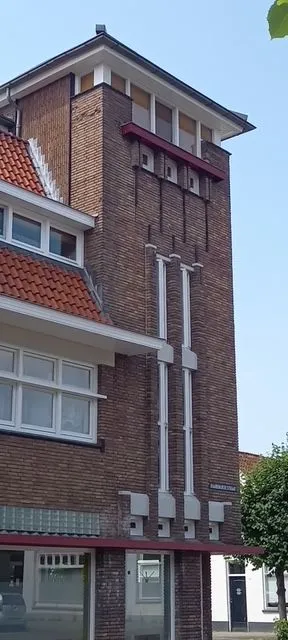 De ingangstoren heeft
veel kenmerken van de bouwstijl Amsterdamse School