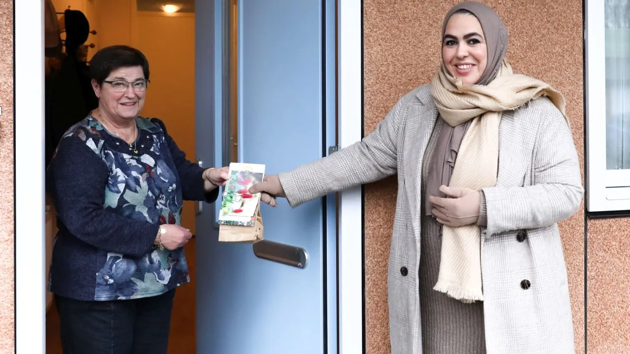 2020 12 04 wethouder nadya aboyaakoub akkouh deelt zakjes met bloembollen uit aan mevrouw van t land gemeente nijkerk