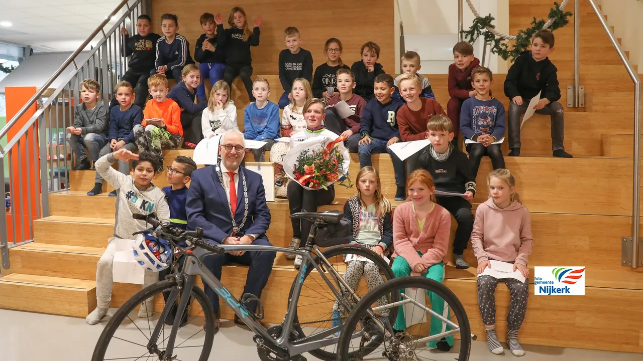 221216 stadspenning voor marieke van soest met burgemeester gerard renkema haar tribike en leerlingen maranthaschool 2