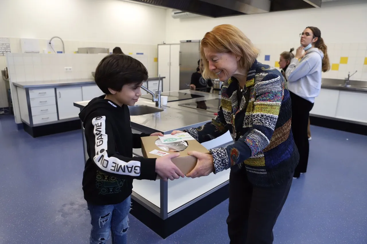 wieke bonthuis van jong leren eten gelderland overhandigt de eerste maaltijdbox aan wessam bedenker van het recept