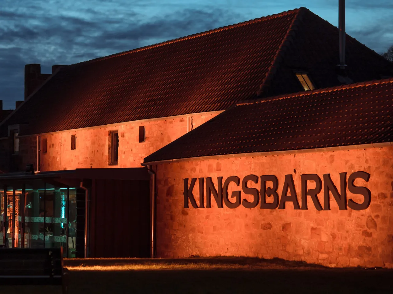 De prachtig verlichte distilleerderij in de avond