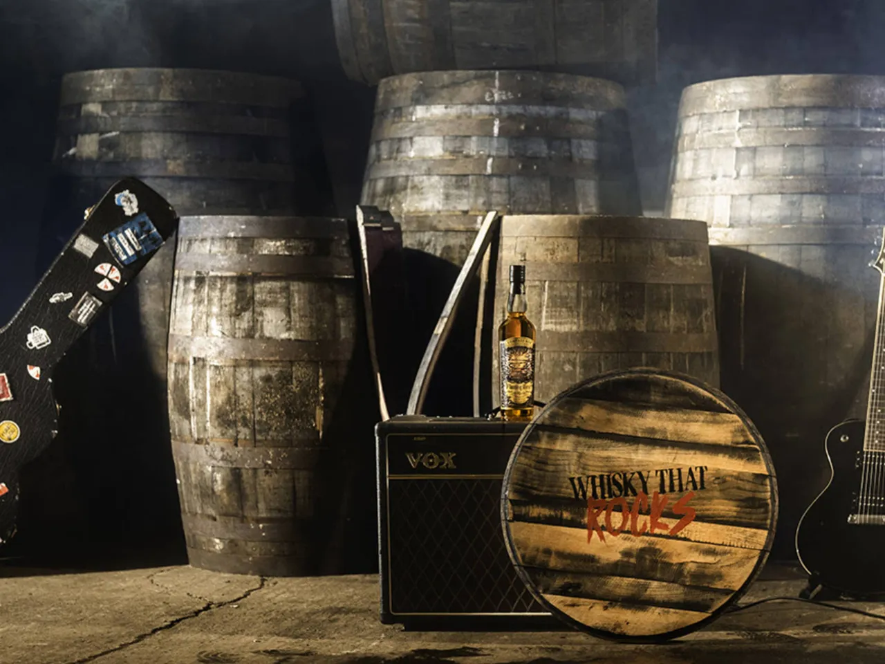 Compass Box Flaming HEart 25th Anniversary Edition bij vaten, een speaker, een gitaar en een vatdeksel met de tekst Whisky That Rocks