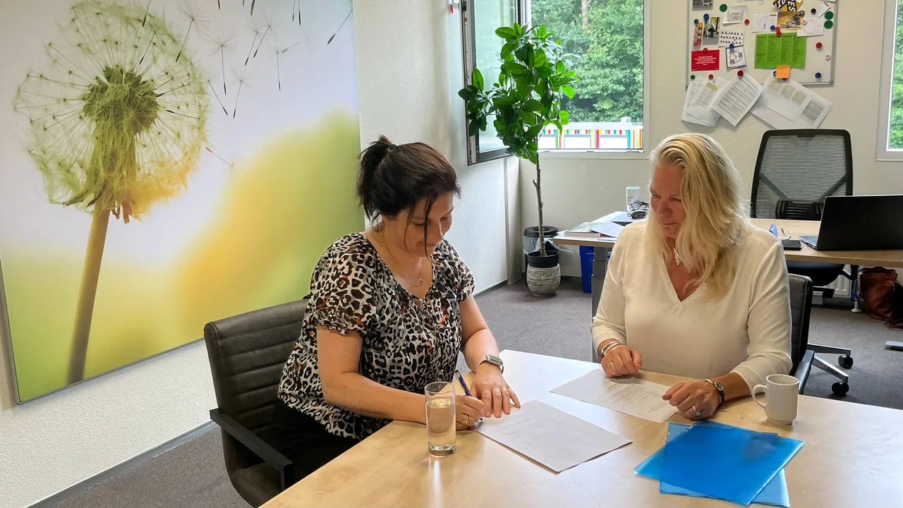 Mirjam Geers (links) en Carin Veringa (rechts) tekenen huurcontract en intentieverklaring