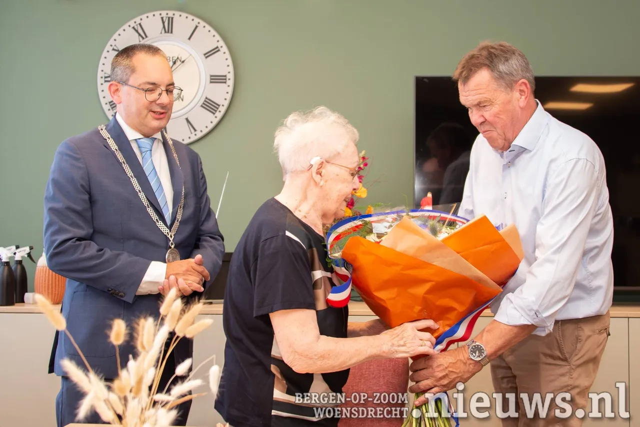 Uit handen van haar neef, wethouder Rainier Schuurbiers, ontving&nbsp;mevrouw Van Ginnekende bloemen