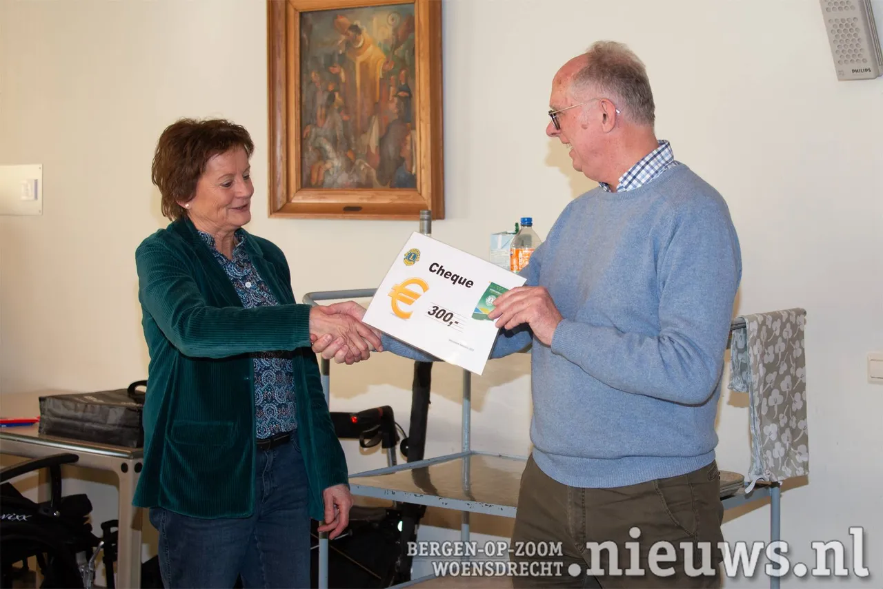 Een cheque van €300,- voor De Zonnebloem