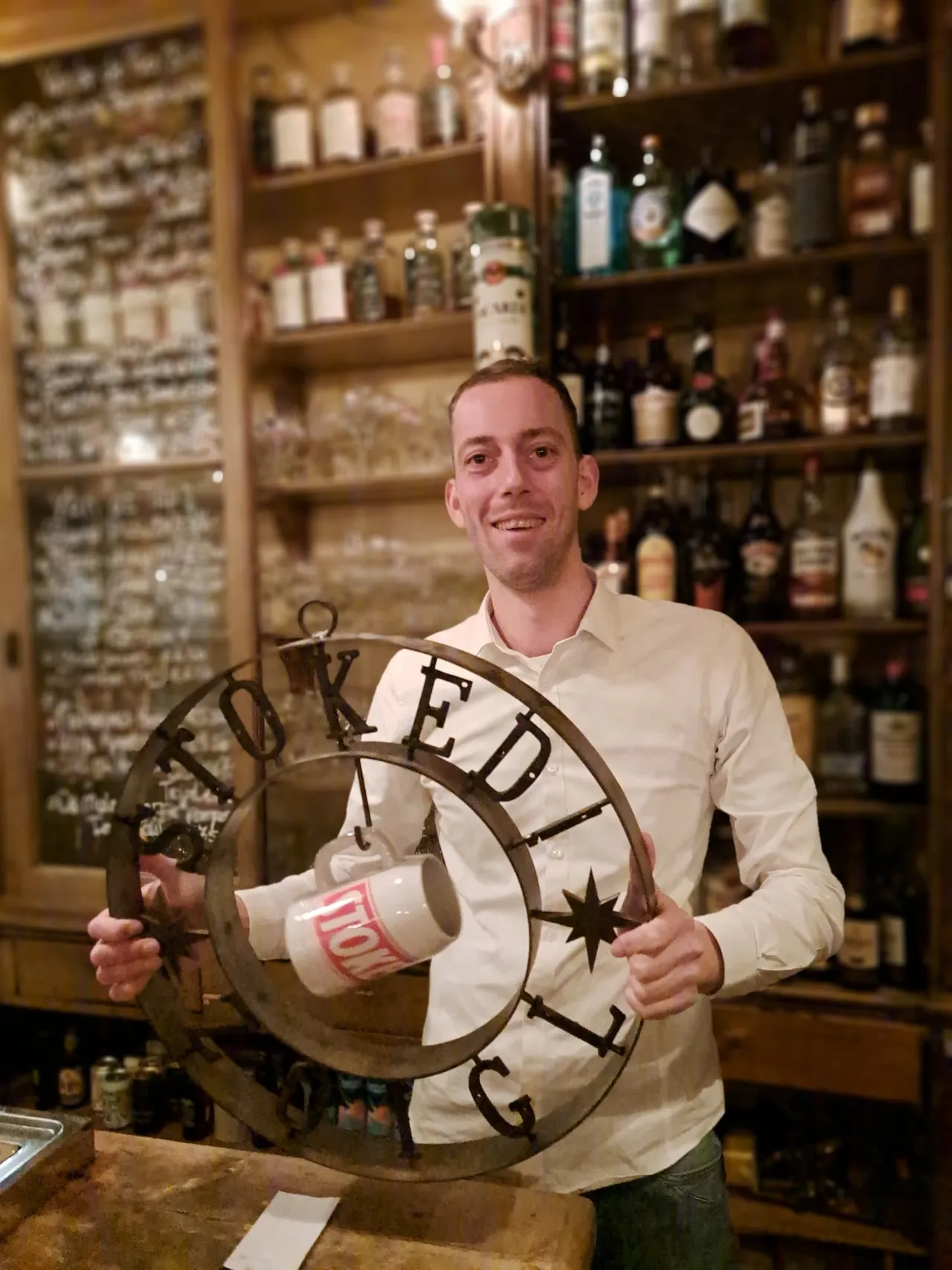 eigenaar justin van the black smith houdt het zoigl bord vast