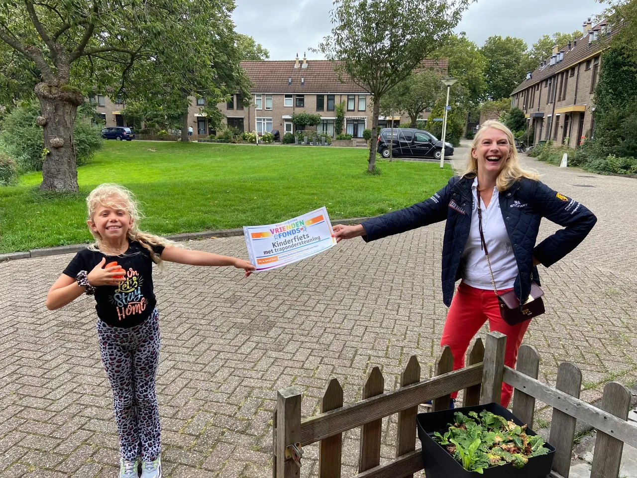 een dolblije elize met de cheque van het vriendenfonds van de vriendenloterij 1