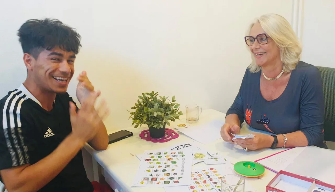taalcoach marcia en deelnemer nesar zijn bezig met taaloefeningen en taalspelletjes om zo de woordenschat van nesar te vergroten foto 2 fotograaf stichting piezo