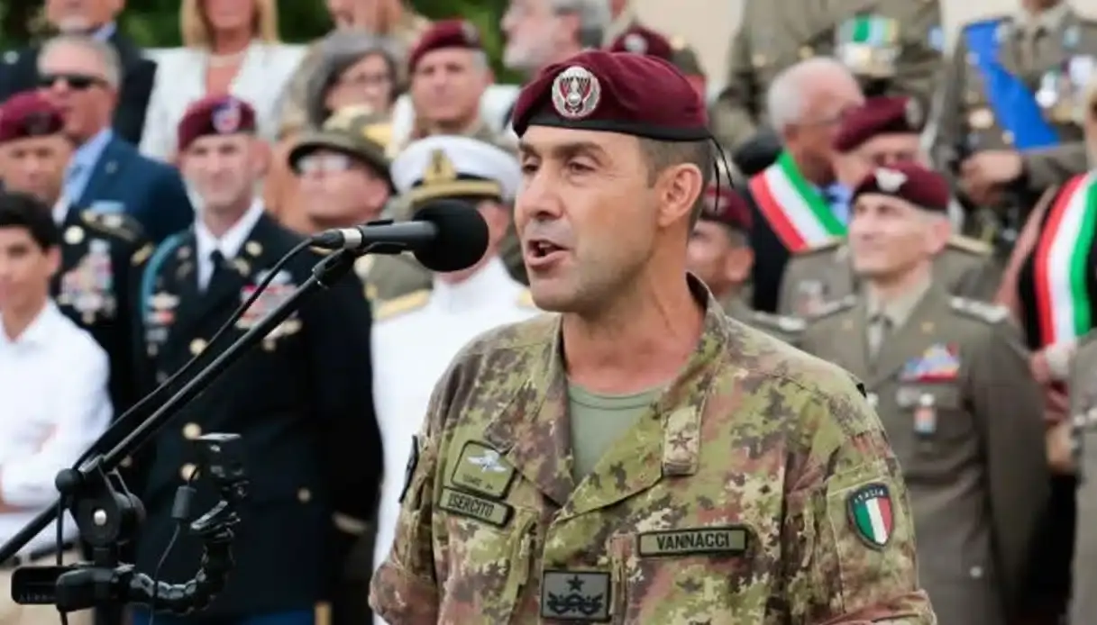 generale vannacci parla al microfono con sfondo militari