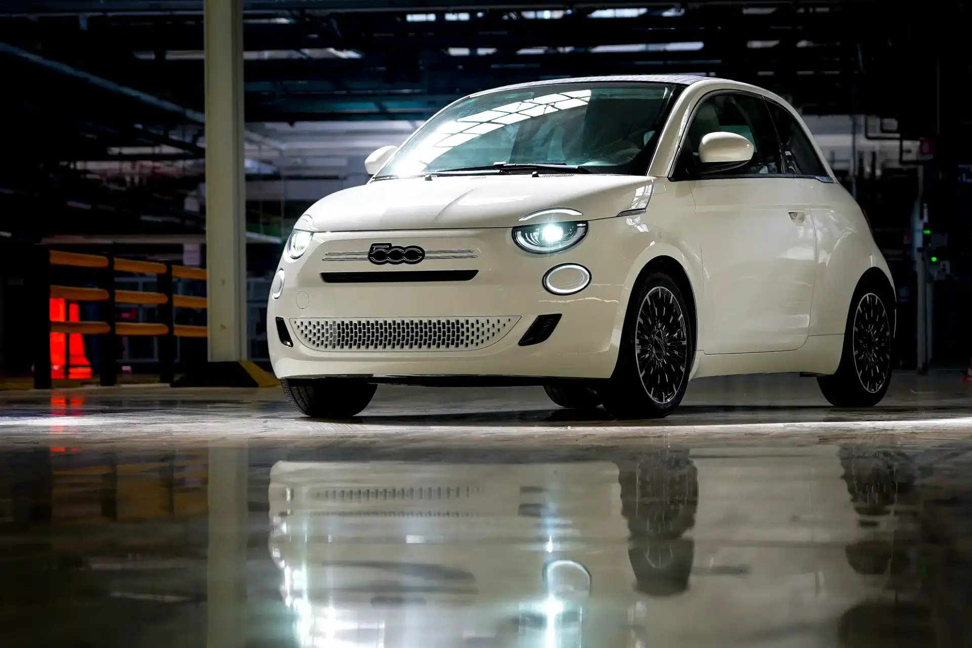nuovafiat500hybridamirafiori bianca con sfondo fabbrica