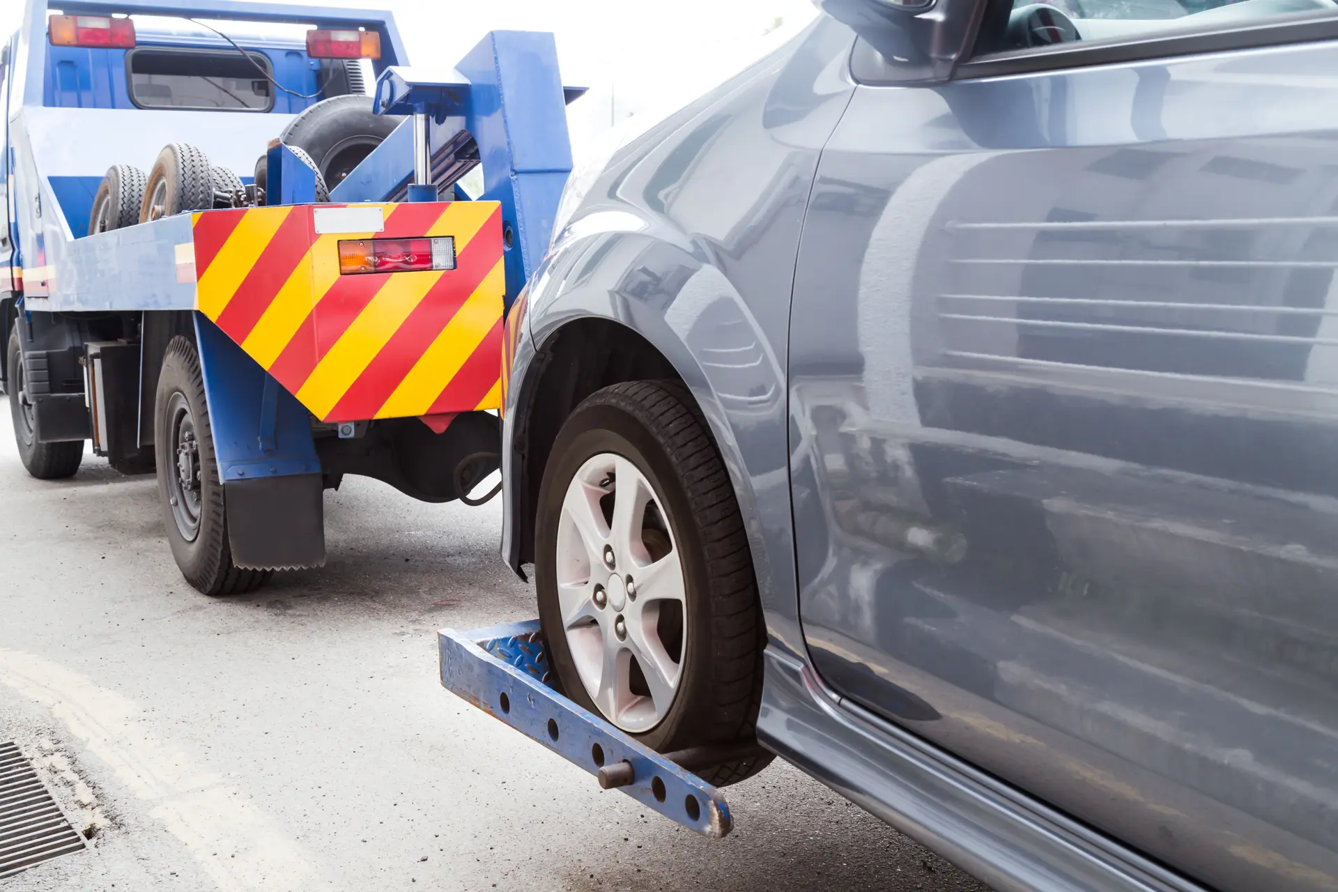 tow truck towing a broken down car on the street pe9hh3a