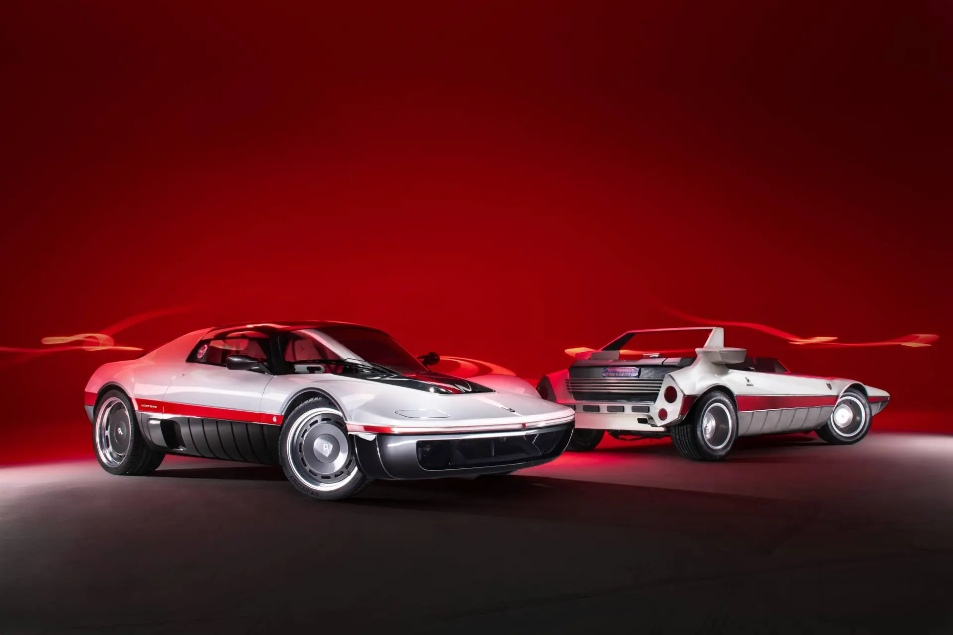 Riedizione Bertone Runabout in vista anteriore e posteriore con sfondo rosso