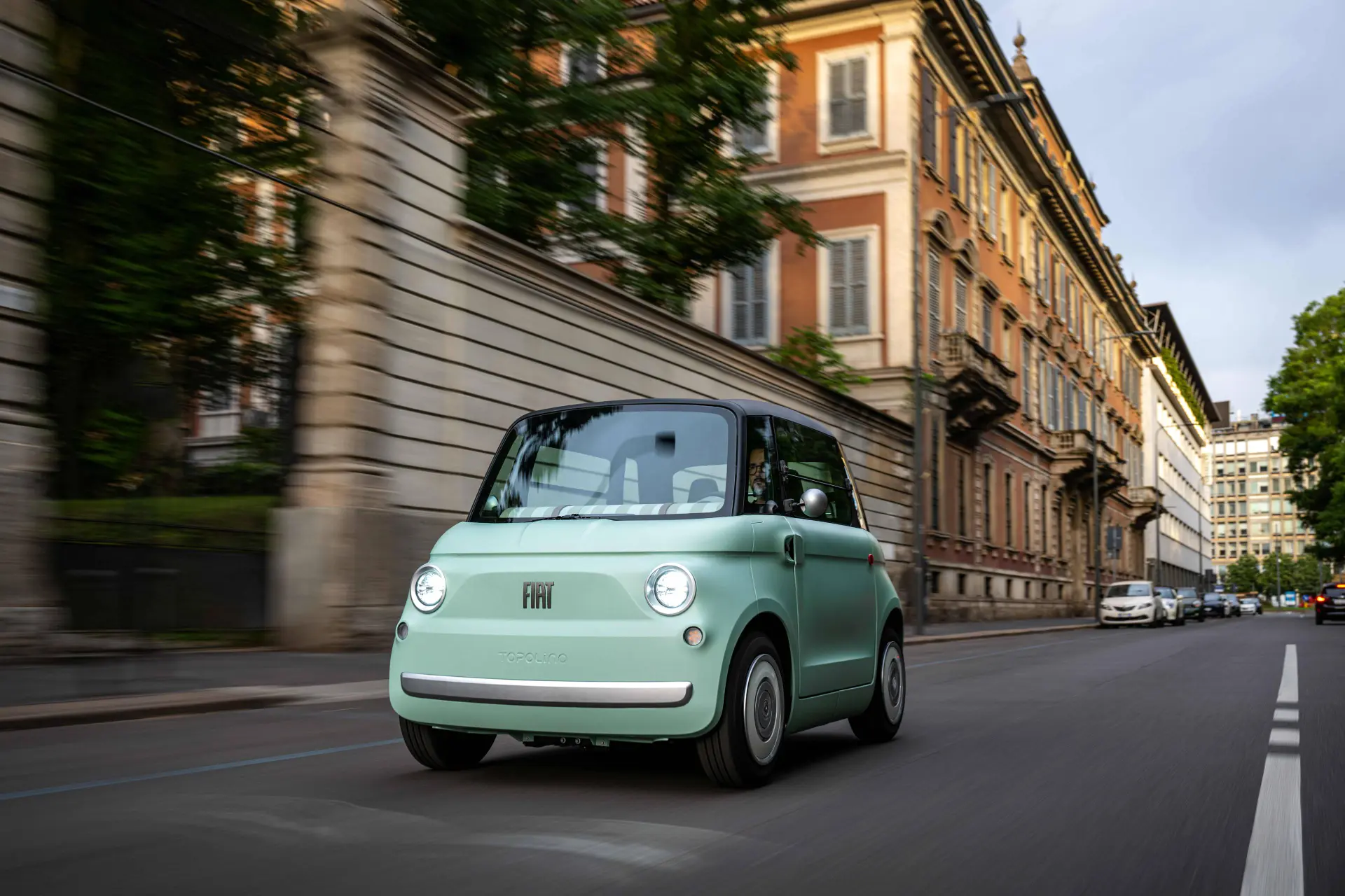 La FIAT Topolino ripresa di fronte su una strada in città di colore verde menta