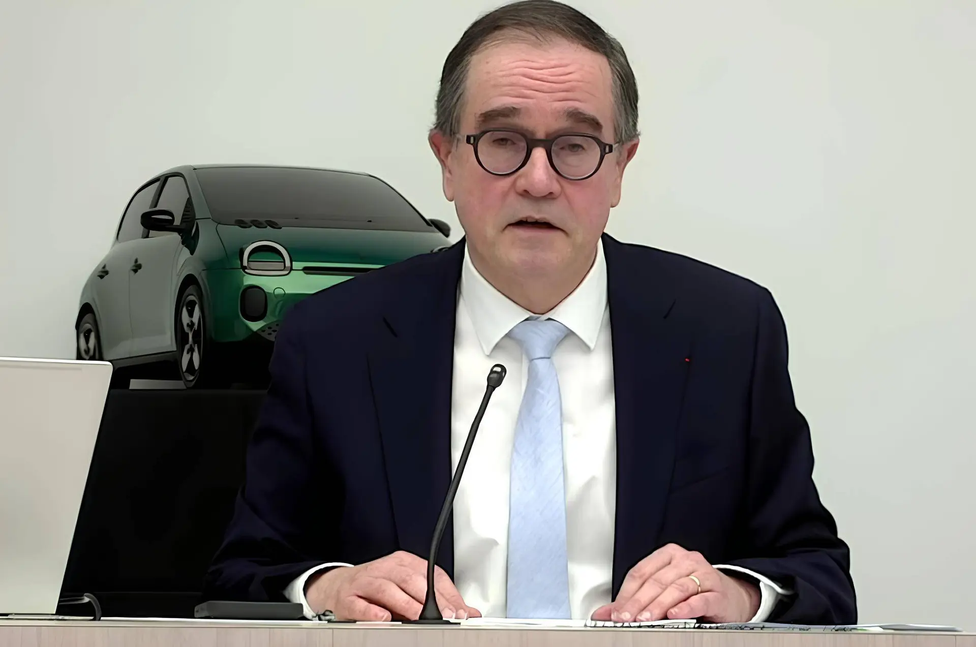 Nell'immagine si vede il CEO di Renault, Francois Provost, che parla davanti ad un microfono e sullo sfondo si vede la nuova Renault Twingo