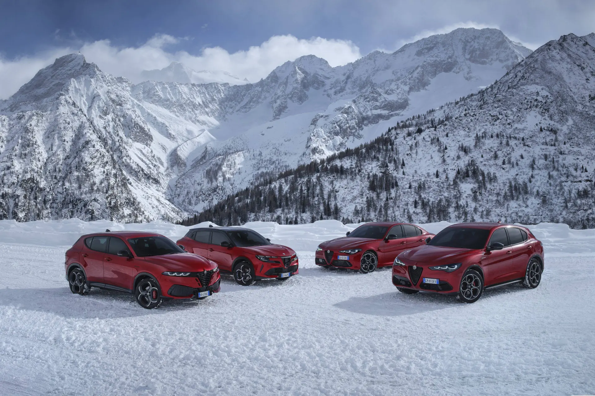 La gamma Q4 di Alfa Romeo sulla neve. Quattro modelli rossi di alfa, da sinistra Stelvio, Junior, Giulia e Tonale