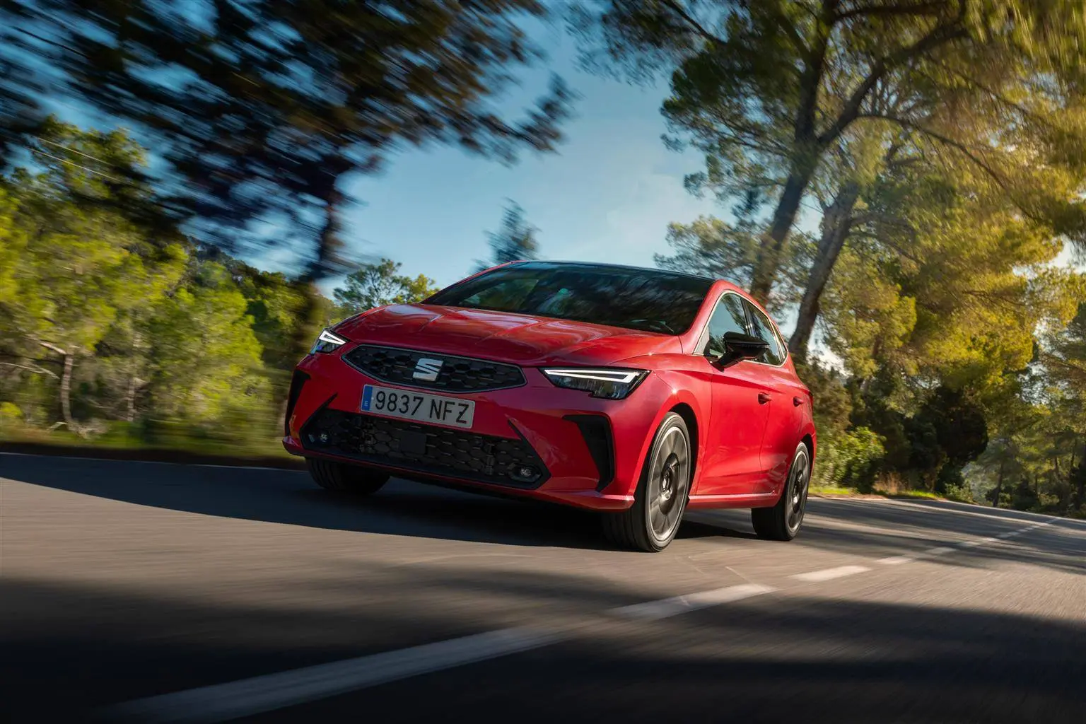 seat ibiza di colore rosso che percorre strada anteriore