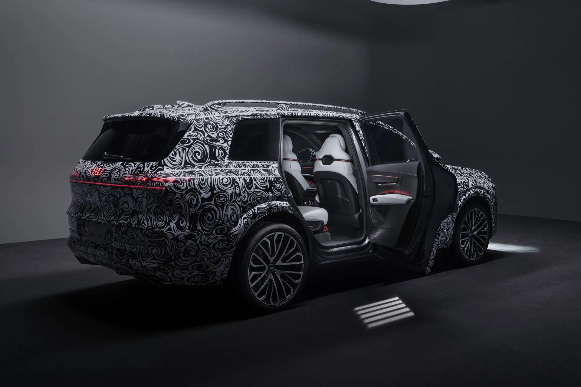 Audi Q9 vista da dietro interamente camuffata con la portiera posteriore aperta