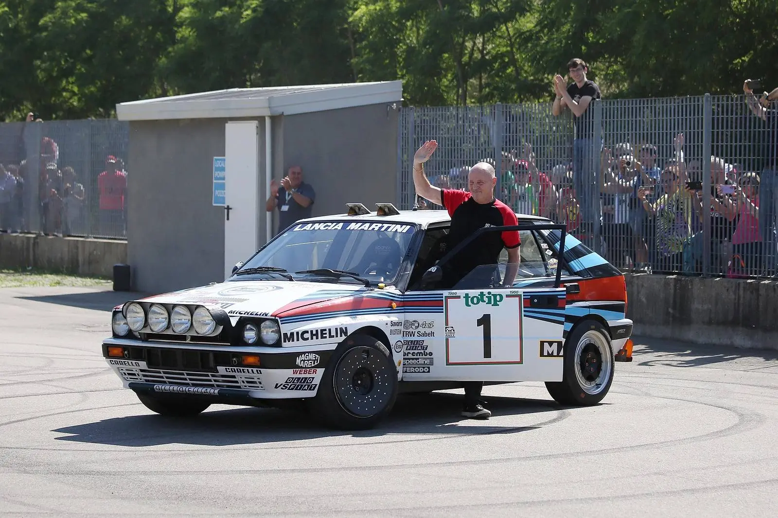 Pilota Miki Biasion con Lancia Delta campione sfondo pubblico rally