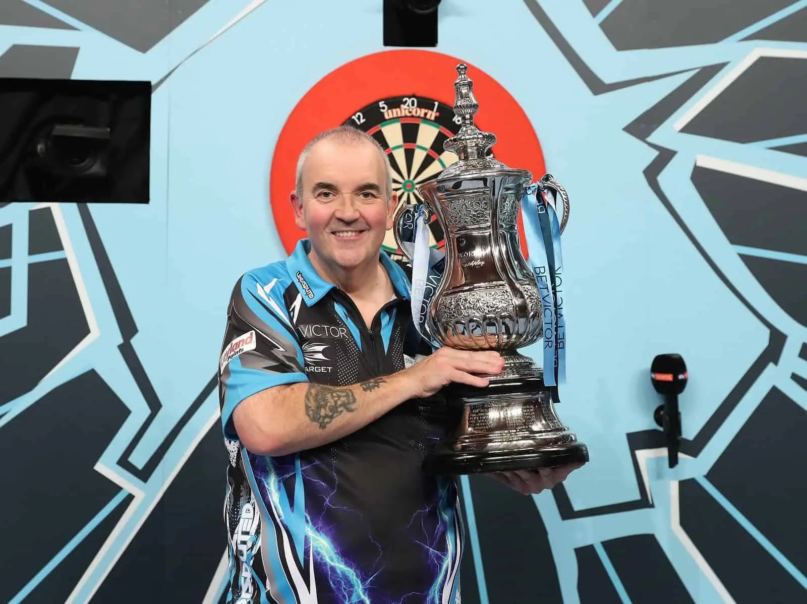 Phil Taylor holds trophy.