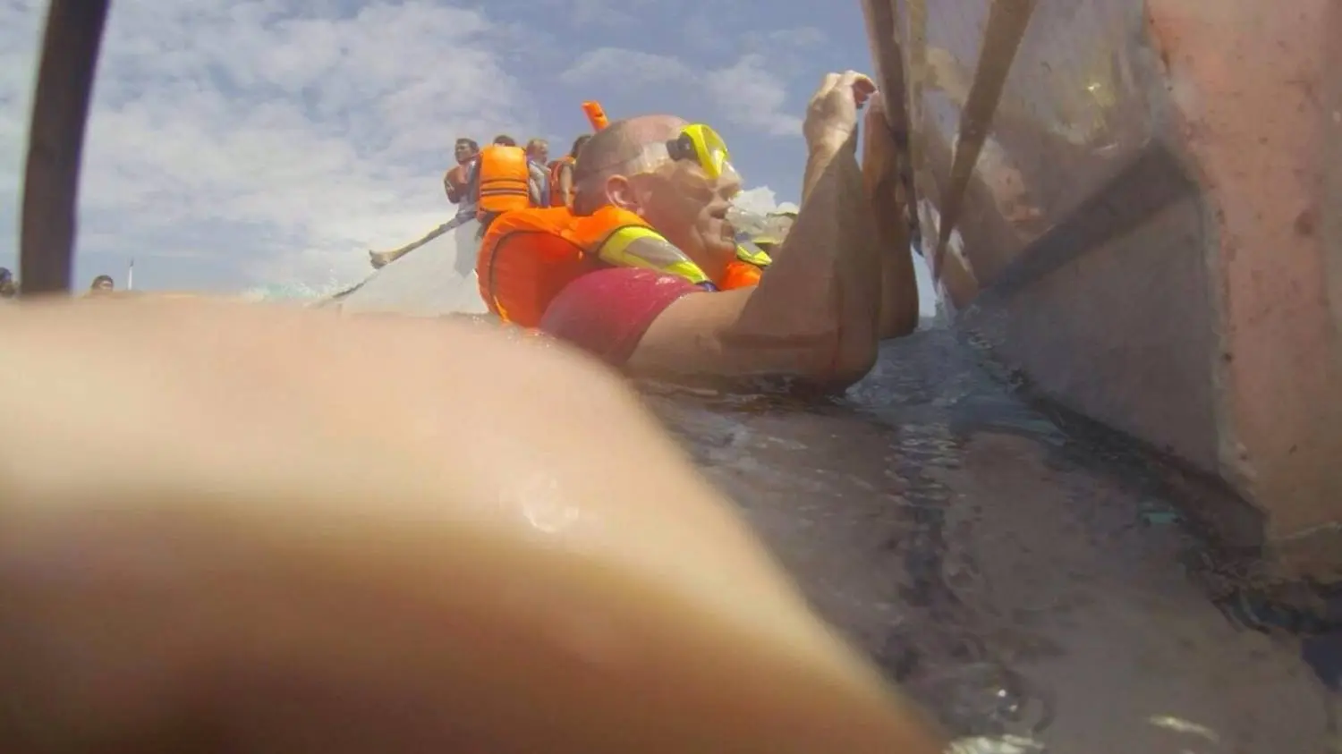 Hangend aan de sloep bij schip
