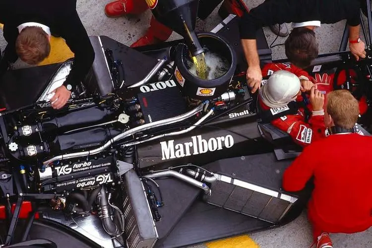 alain prost sits in his mclaren mp4 3 tag porsche while the mechanics get to work on the car and refuel