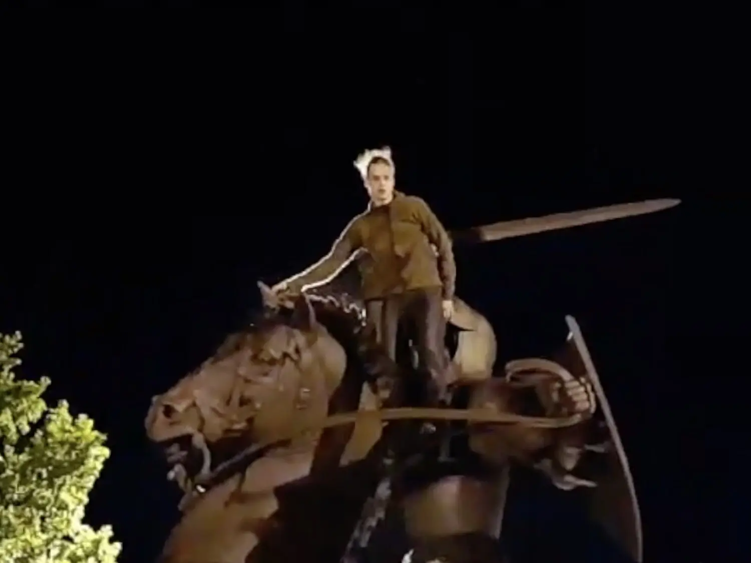 Jaunuolis ant Vyčio skulptūros Kaune