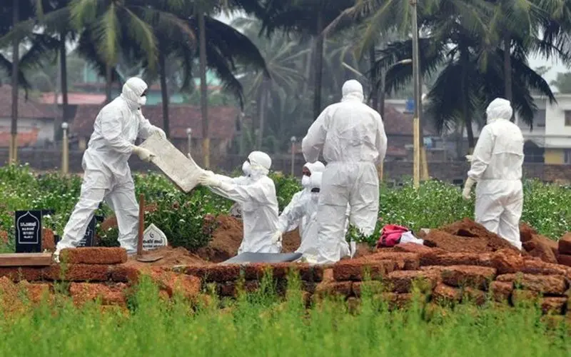 0 Doctors and relatives wearing protective gear dig a grave to bury the body of a victim who lost his 1