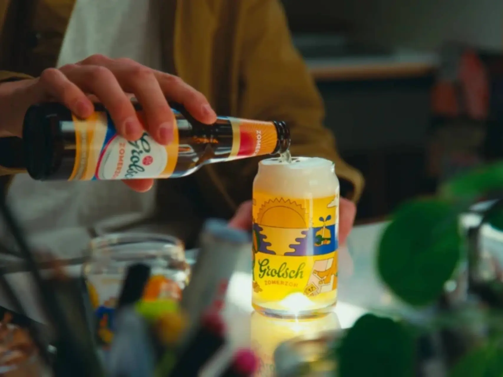 man die grolsch zomerzon in een glas schenkt