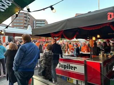 op het wilhelminaplein genieten mensen in de avondzon van live muziek en een biertje