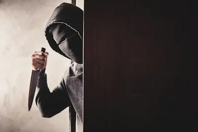 the thief holds a knife to open the house door for robbery overvaller met mes