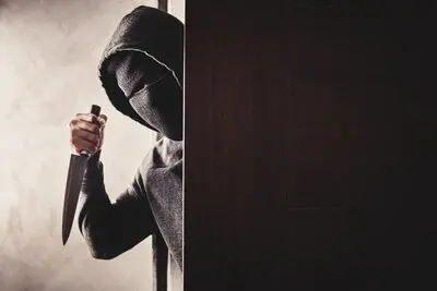 the thief holds a knife to open the house door for robbery overvaller met mes