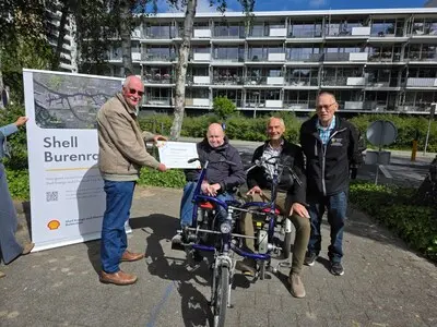 een bewoner nam de cheque in ontvangst van de voorzitter van de burenraad