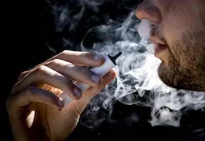 illustratie een jonge man rookt een vaper oftewel een e sigaret anp koen van weel