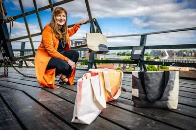 serie afgekocht adr ar20250515 3424 dordrecht foto van mevrouw die tassen van de wieken van de molen bedacht