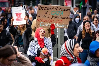 een van de demonstranten zondag draagt een bord bij zich waarop ze zich richt tot burgemeester schouten