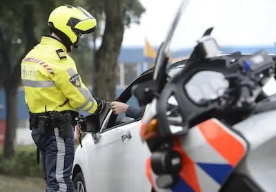 illustratie een agent controleert het rijbewijs van een automobilist anp xtra lex van lieshout