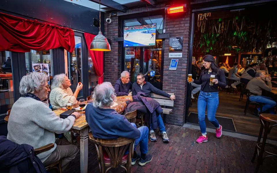 marjanne20fransen20rechts20serveert20drankjes20terwijl20gasten20in20cafc3a920it20houtsje20samen20een20schaatswedstrijd20volgen20op20de20schermen