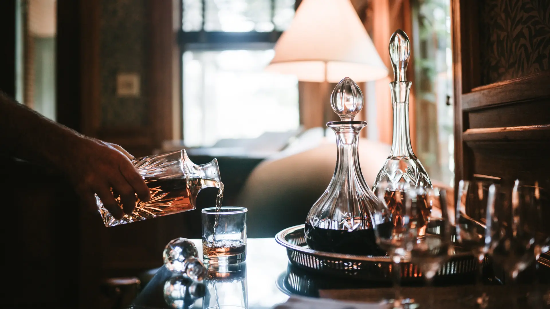 Whisky decanter en whiskyfles bij een lamp