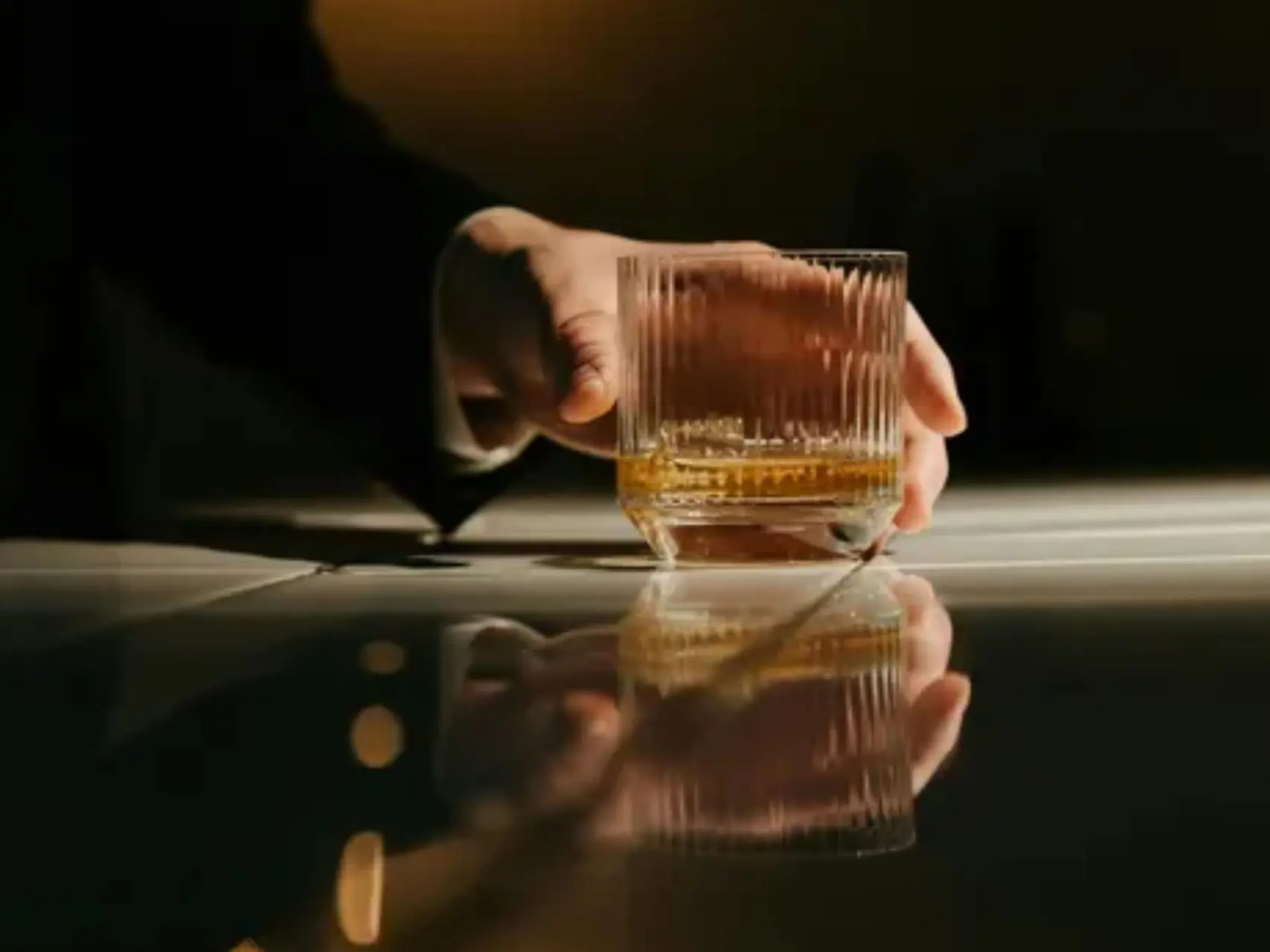 hand met glas whisky